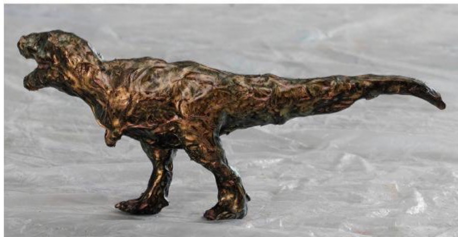 褐色の絵具で表面を覆った恐竜フィギュア
