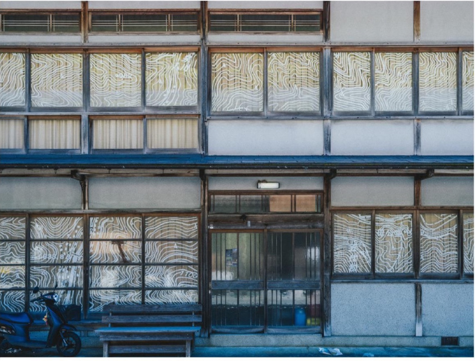 木造建築の窓ガラスに白い等高線を描いた波と表面の全景