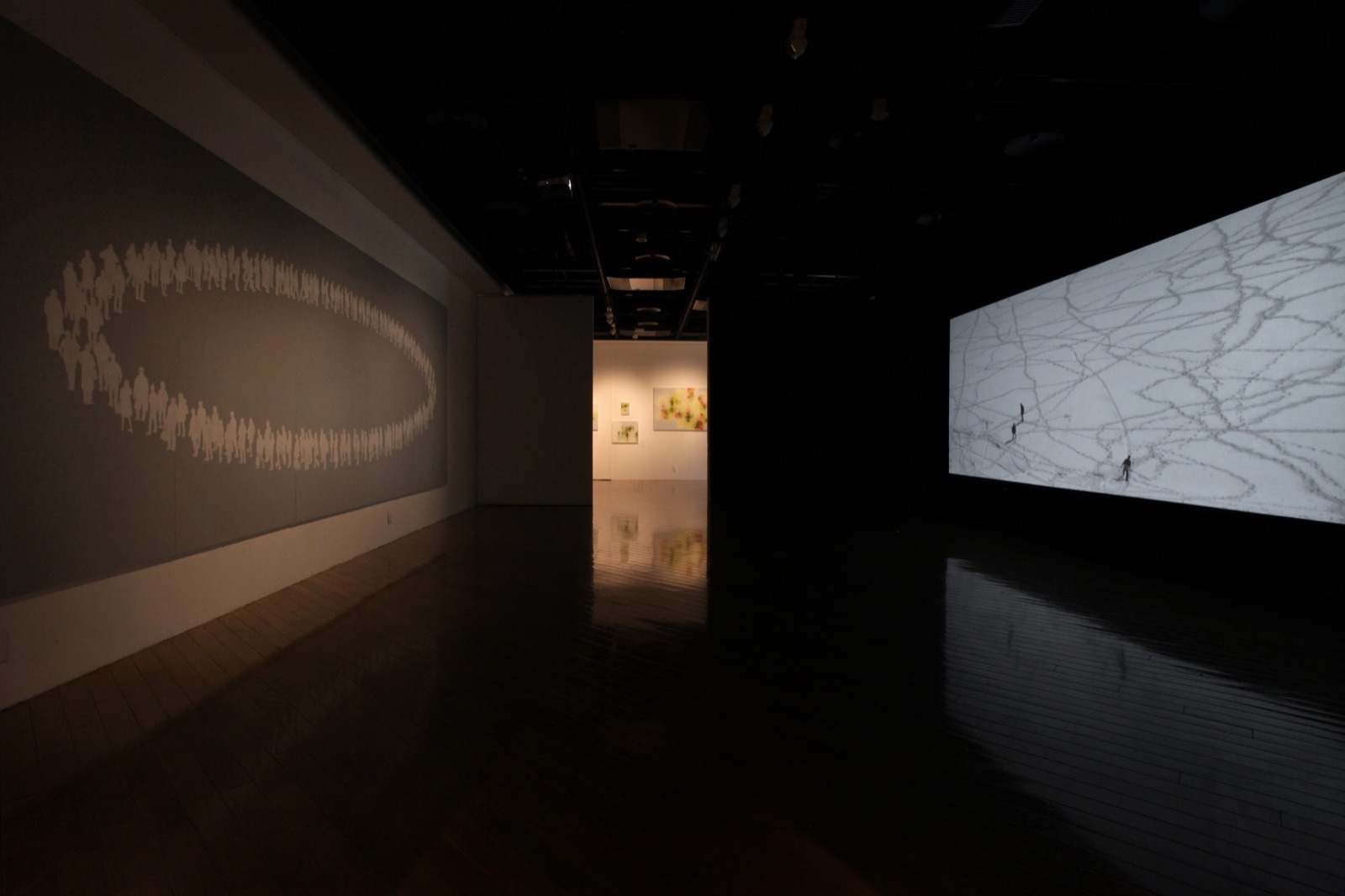暗い会場で映像作品と展示されたScene (Oval)